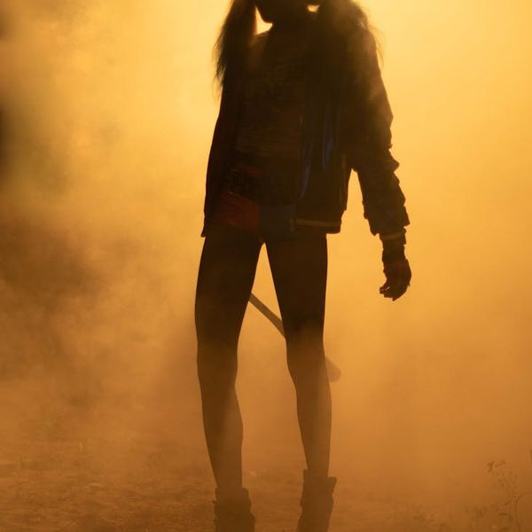 Silhouette of a person in a strong yoga warrior pose at sunset.